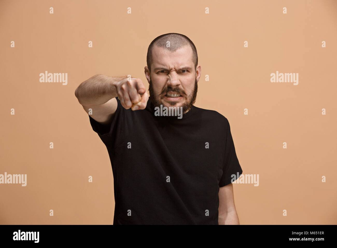 L'homme dominateur et vous voulez vous point, demi-longueur closeup portrait sur fond pastel. Banque D'Images