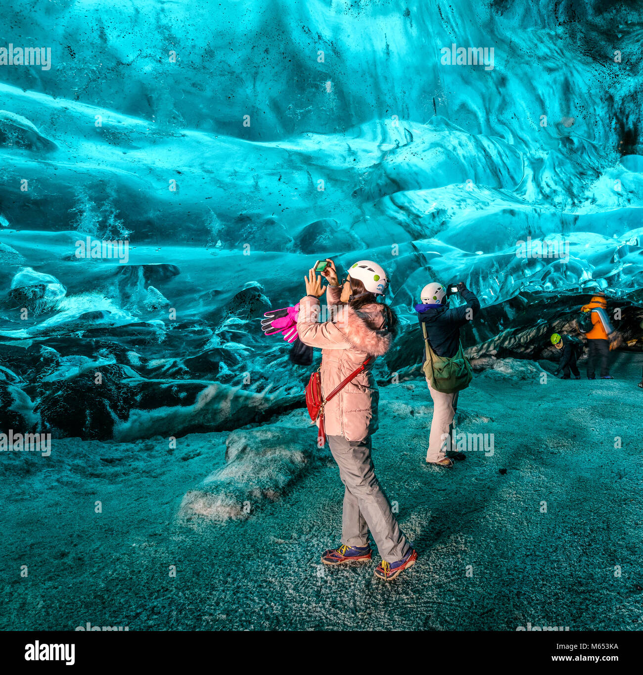 Les touristes dans la grotte de cristal, Glacier Breidamerkurjokull, Islande. La glace bleue émeraude et le frêne fait partie d'Breidamerkurjokull. Banque D'Images