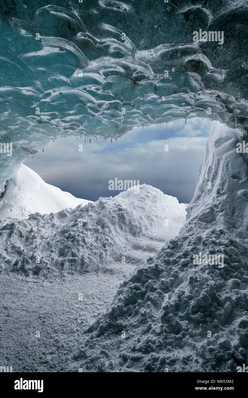 Les touristes dans la grotte de cristal, Glacier Breidamerkurjokull, Islande. La glace bleue émeraude et le frêne fait partie d'Breidamerkurjokull. Banque D'Images