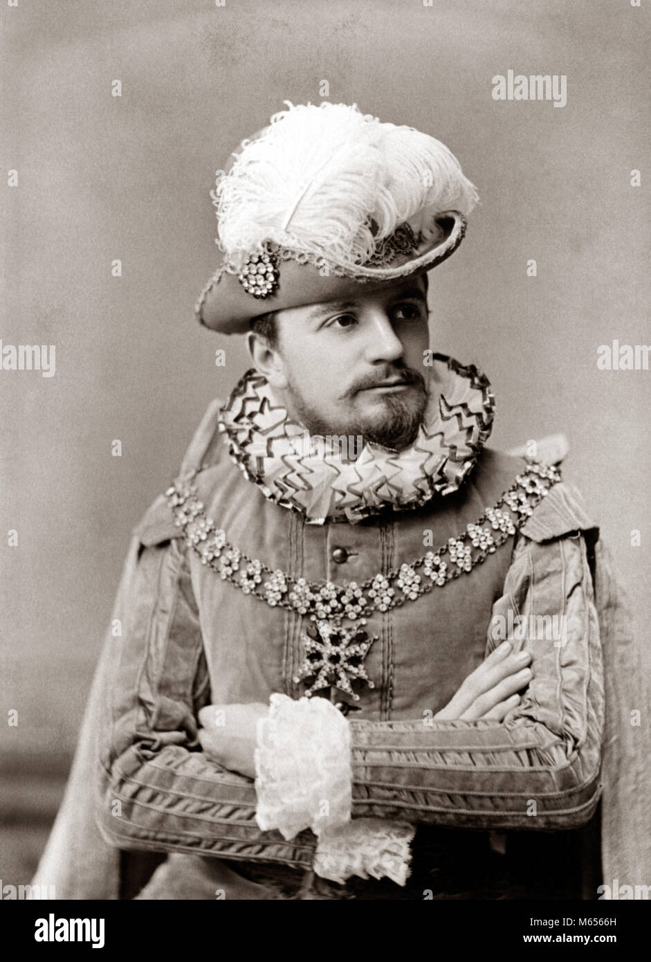 Années 1890, l'homme ACTEUR DANS ELIZABETHAN COSTUME FASHION COL & POIGNETS  ÉBOURIFFÉ TUNIQUE VELOURS chapeau avec grand panache de plumes et barbe -  c10748 HAR001 à l'INTÉRIEUR DE LA STATION DE RECHERCHE