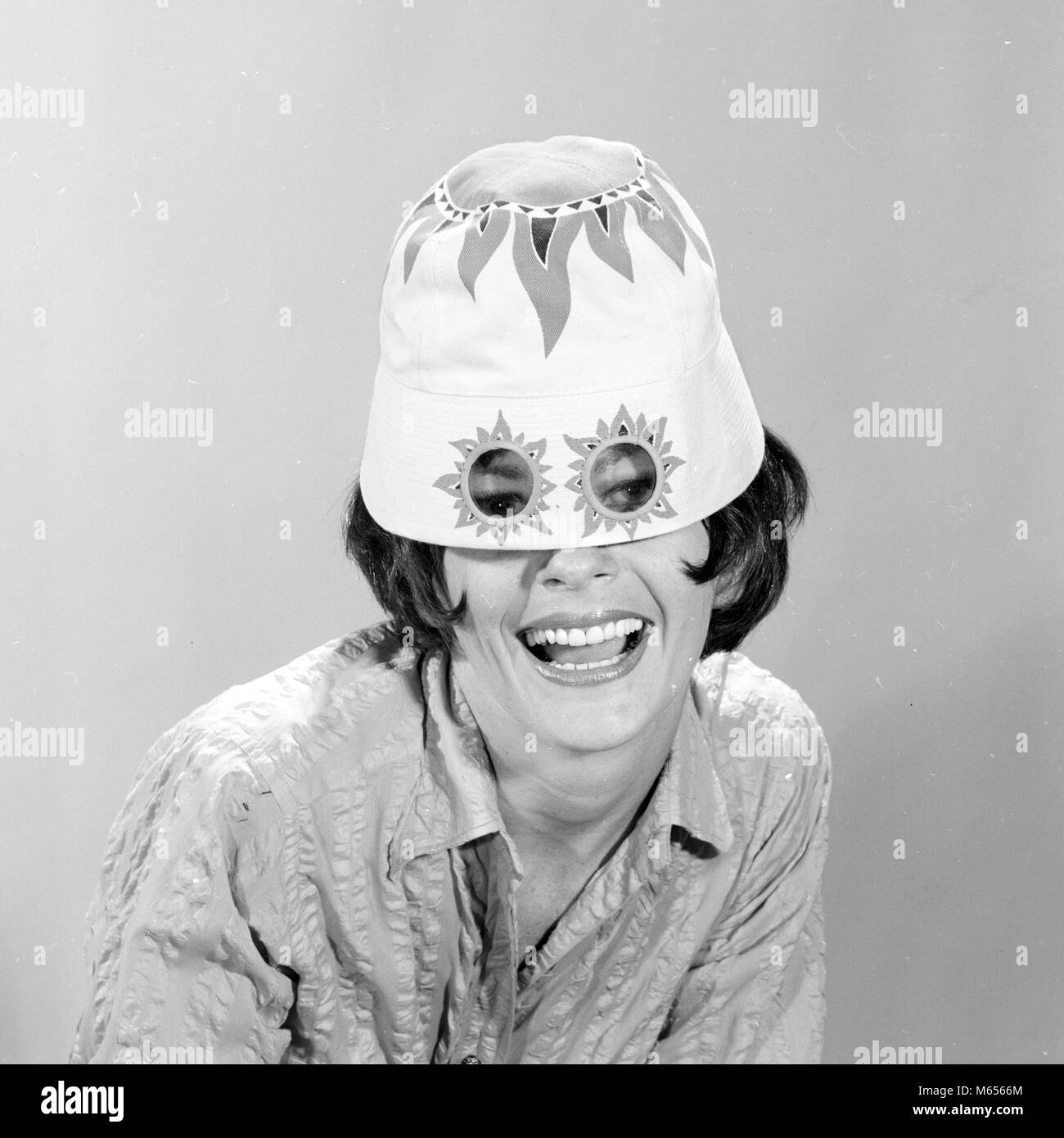 1960 SMILING WOMAN WEARING SUN HAT WACKY DRÔLE AVEC LES TACHES SOLAIRES POUR LES LUNETTES LOOKING AT CAMERA - c10634 HAR001 lunettes à l'intérieur de la station de nostalgie dans les yeux de 20 à 25 ans 25 à 30 ans LA TÊTE ET ÉPAULES BIZARRE NON CLASSIQUE LOUFOQUES JOYEUX JOYEUX SOURIRES échapper à la mode excentrique AMUSANT IDIOSYNCRASIQUES WACKY TROUS JEUNE ADULTE FEMME B&W NOIR ET BLANC bord irrégulier de l'origine ethnique caucasienne LOOKING AT CAMERA OLD FASHIONED PERSONNES SUN HAT TACHES Banque D'Images