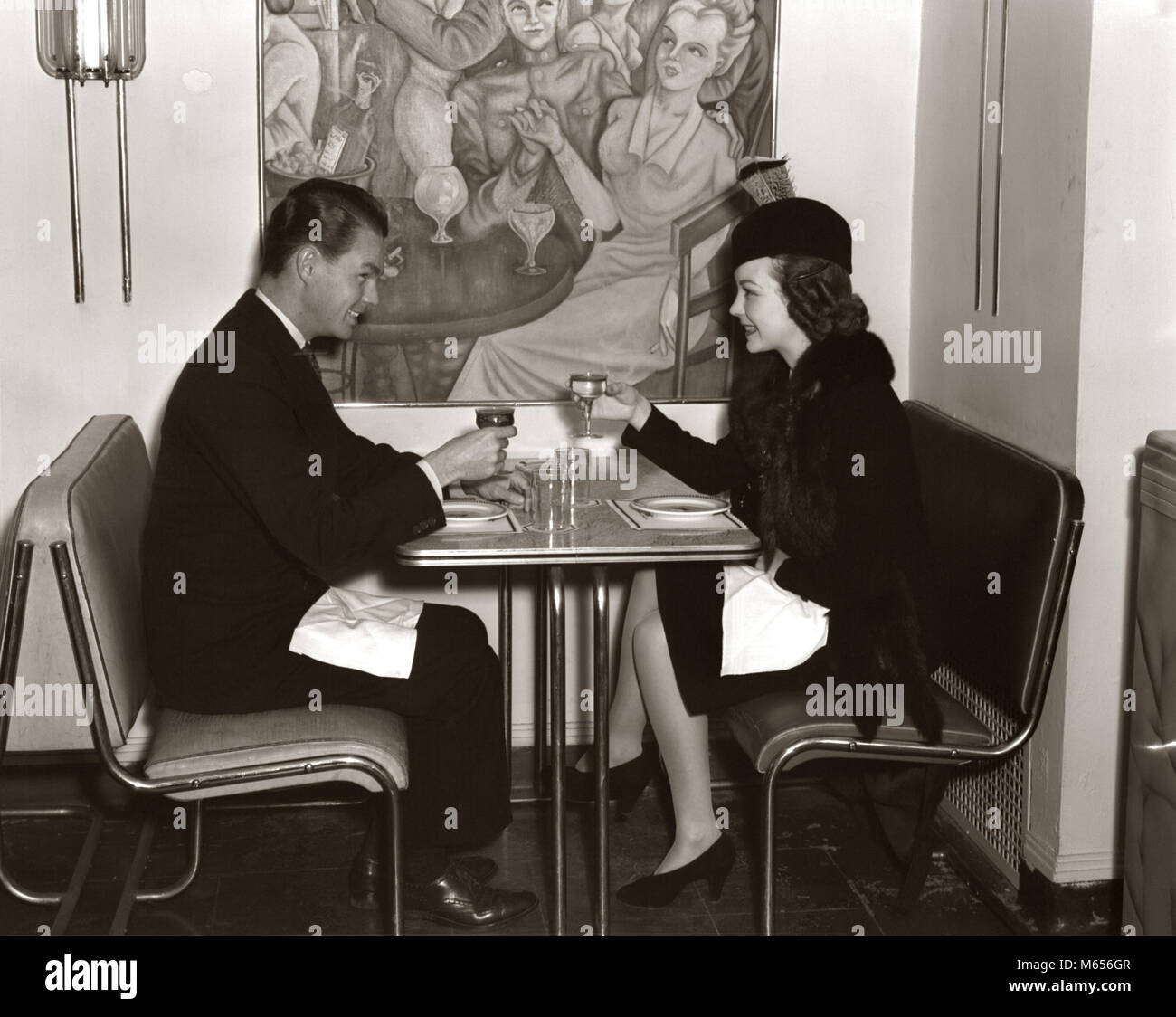 1940 SMILING YOUNG COUPLE HOMME FEMME SIÉGEANT ENSEMBLE SUR CHROME STYLE ART DÉCO TABLE ET CHAISE MOBILIER DE CAFÉ moderne - d456 HAR001 HARS CÉLÉBRATION DE VIE MODERNE GROWNUP FEMELLES PLEINE LONGUEUR D'AMITIÉ MESDAMES ADULTE, DES COUPLES à l'intérieur de la nostalgie l'unité de 20 à 25 ans recherchant CAFE BOISSON LIQUIDE DÉCOR NOURRIR TOAST TOAST CONNEXION SUR L'ALIMENTATION DES JEUNES ADULTES MÂLES CHROME UN AUTRE JEUNE HOMME FEMME ADULTES DÉCO ART B&W NOIR ET BLANC PORTRAIT DE L'ORIGINE ETHNIQUE DES PERSONNES À L'ANCIENNE Banque D'Images