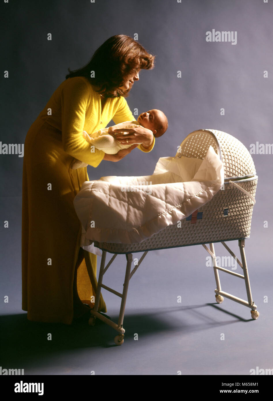1970 Mère Robe Jaune Portant La Mise En Sommeil De Bébé Enfant En Osier  Tissé Blanc Couffin - Kb12365 Har001 Hars Coucher Caucasian Fils La Joie  D'être Parent Vie Studio Shot Accueil
