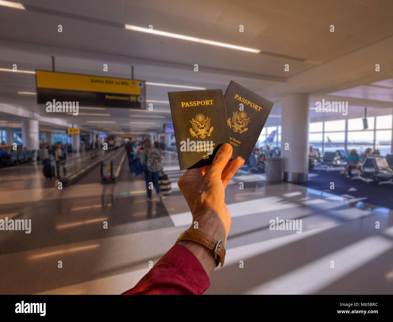 Main tenant deux passeport américain en face d'une compagnie aérienne d'embarquement gate Banque D'Images