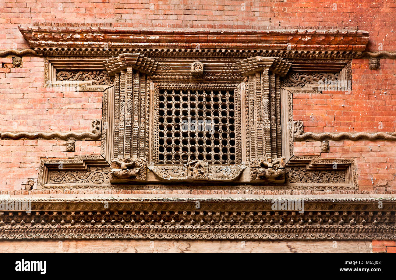 Fenêtre en bois sculpté sur l'ancien Palais Royal Hanuman Dhoka, Durbar Square de Katmandou, Népal. Banque D'Images