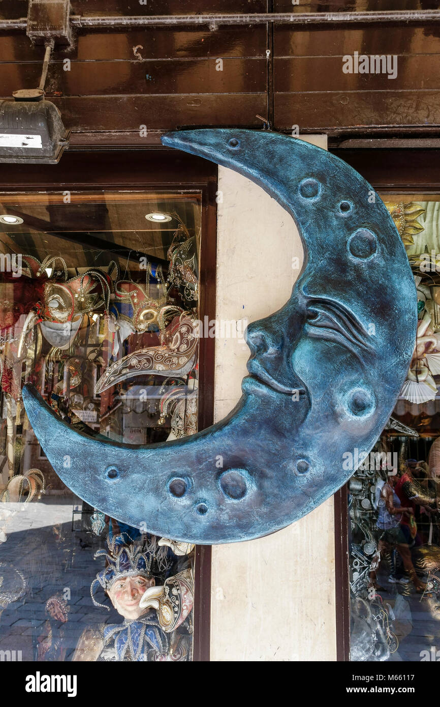 Grande demi-lune sculpture, comme signe, à l'extérieur d'une boutique typique de masques de carnaval vénitien. Venise magique, Italie, Europe, Union européenne, UE. Banque D'Images