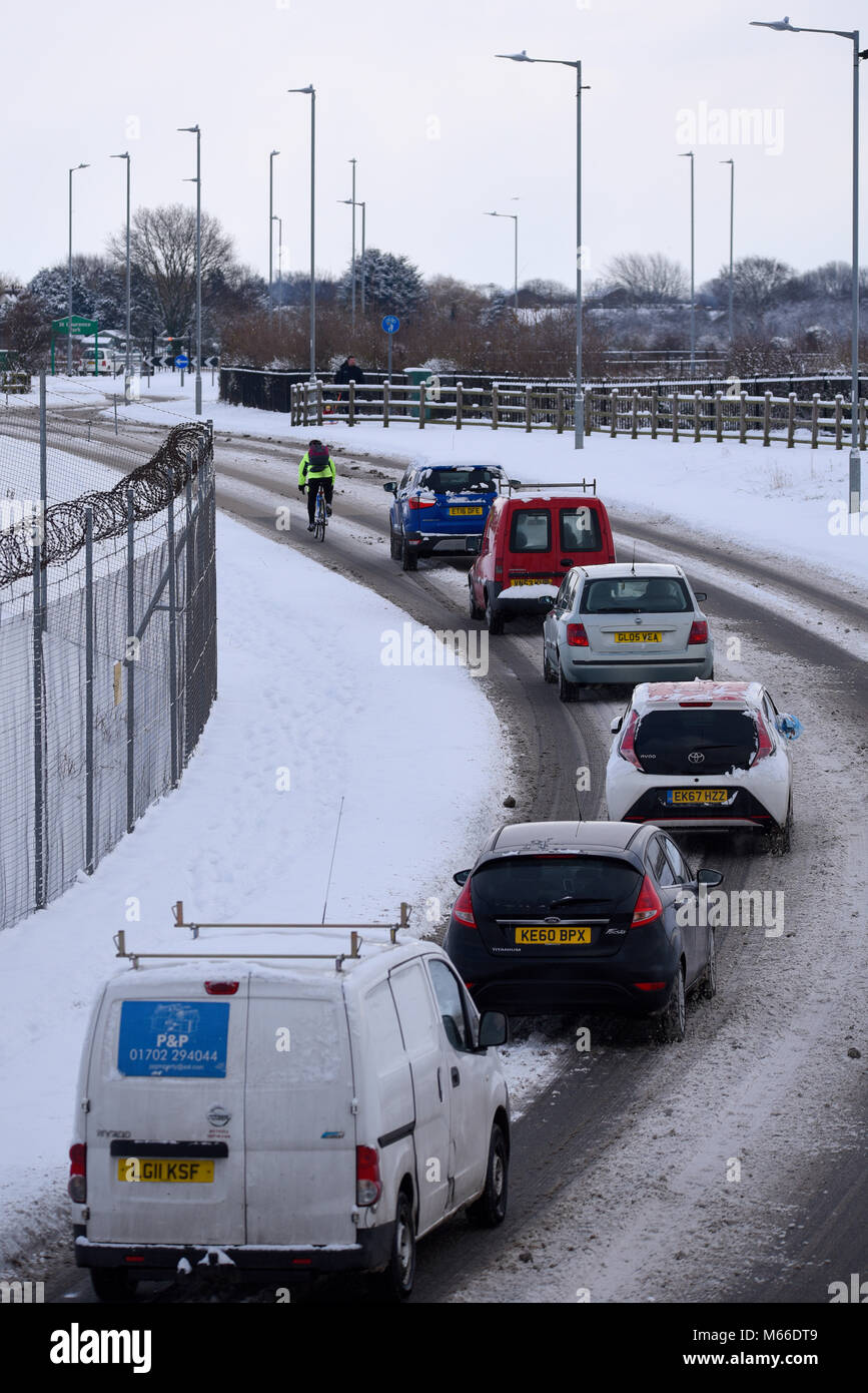 Les voitures de queue coincé derrière un cycliste sur une route couverte de neige au cours de la bête de l'est les phénomènes météorologiques. En tenant le traffic Banque D'Images
