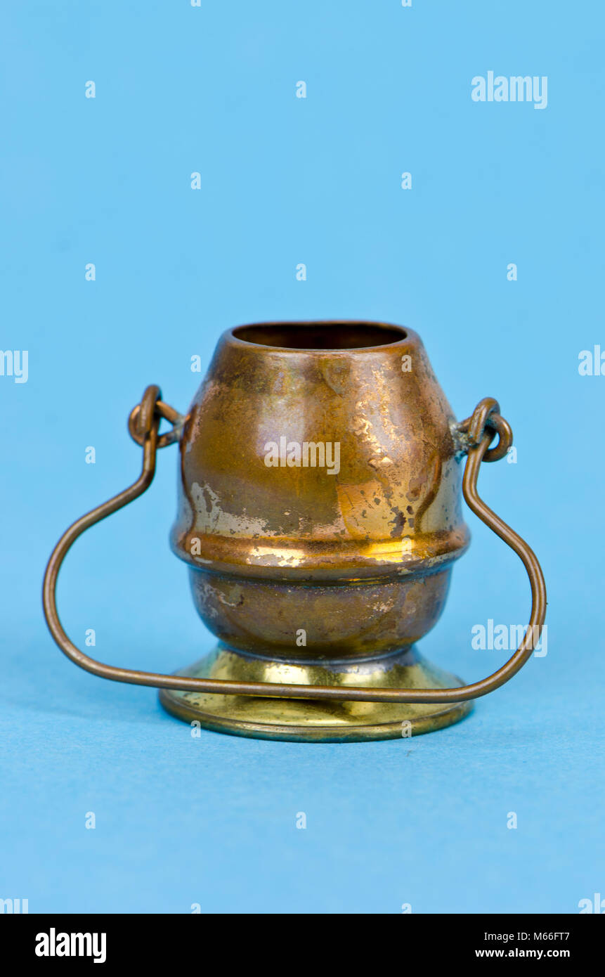 Marmite en cuivre laiton décoratif avec poignée sur fond bleu azur Banque D'Images