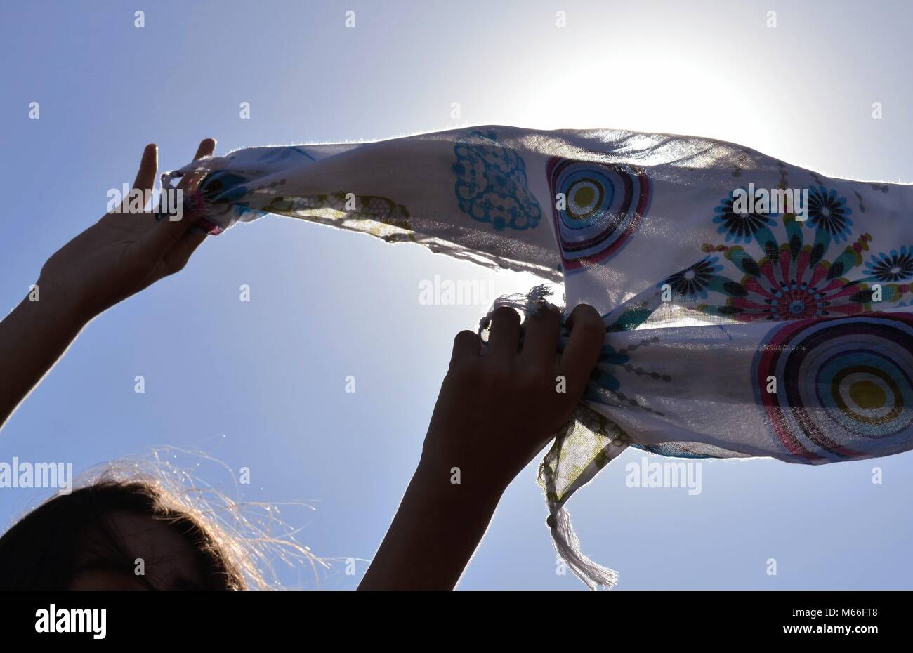 Low angle view of a Girl holding un sarong au-dessus de sa tête Banque D'Images