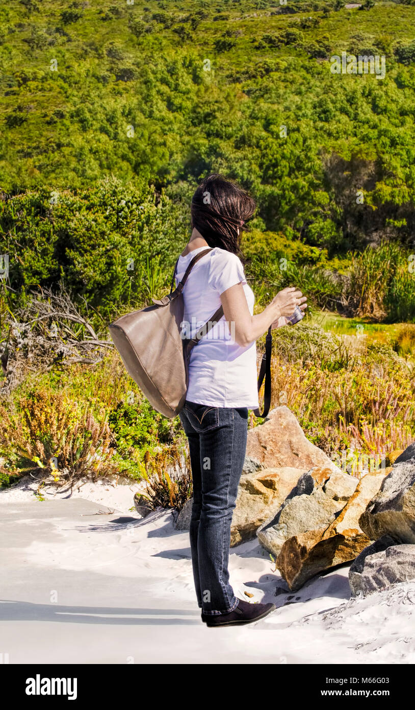 Femme debout sur la plage avec son appareil photo, Australie occidentale, Australie Banque D'Images