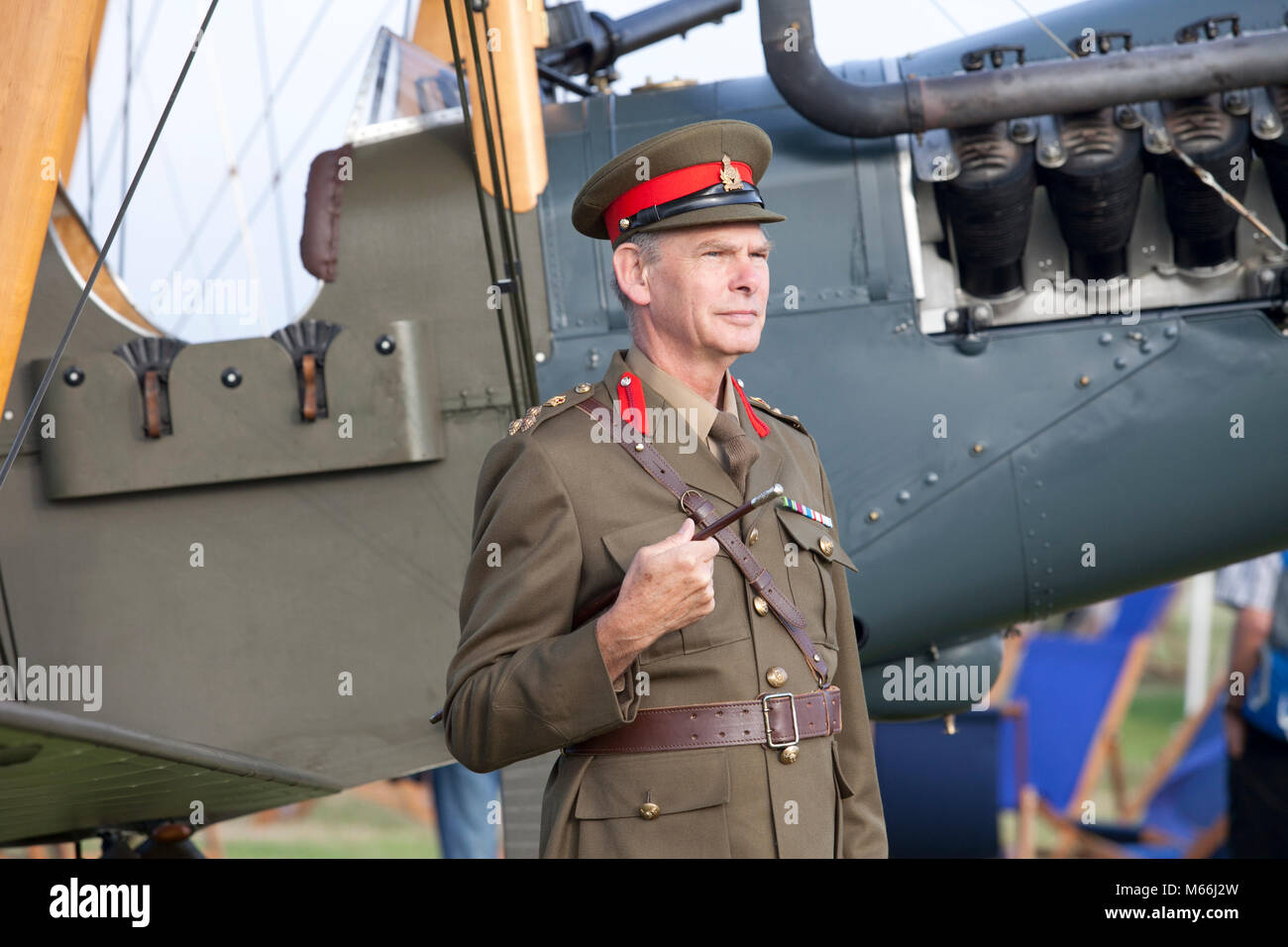 Goodwood Revival, l'homme en uniforme avec vintage vintage permanent plan en arrière-plan à la caméra de Banque D'Images