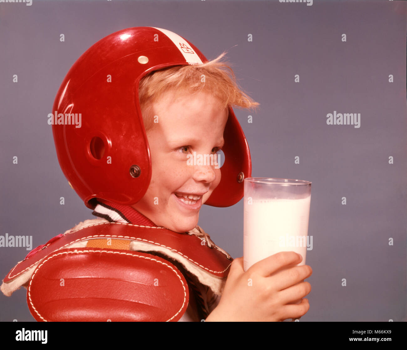 1960 SMILING BLONDE BOY PLASTIQUE ROUGE FOOTBALL HELMET ÉPAULIÈRES HOLDING VERRE DE LAIT - kf3290 HAR001 nostalgie à l'intérieur de la station de recherche de 5 à 6 ans LE BONHEUR DE LA TÊTE ET DES ÉPAULES BIEN-ÊTRE BOISSONS NOURRIR LIQUIDE FORCE DE LA PROTECTION DE LA CROISSANCE DES LOISIRS NUTRITION NUTRITION athlètes mâles juvéniles SPORT ballon de football américain d'épaulettes de l'origine ethnique caucasienne produit laitiers VERRE DE LAIT Old Fashioned Banque D'Images
