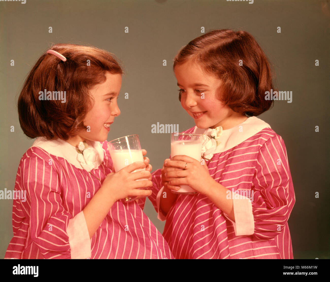 1960 TWIN SMILING BRUNETTE filles portant des robes à rayures rose tenant des verres à boire le lait - kf5430 HAR001 HARS, STUDIO SHOT À RAYURES FEMMES STYLE DE VIE À LA MAISON DE LA SANTÉ COPIE ESPACE AMITIÉ CORRESPONDANCE mi-longueur à l'intérieur de mêmes parents SOEURS NOSTALGIE UNITÉ 1-2 ans 3-4 ans correspondant robes même BONHEUR NOURRIR LA CROISSANCE LIQUIDE BOISSONS JOYEUX sourires d'ENFANT JOYEUSE CONNEXION ALIMENTATION APPARENCE QUE LES JUVÉNILES SE RESSEMBLENT EN DOUBLE Origine ethnique Caucasienne old fashioned clone Banque D'Images