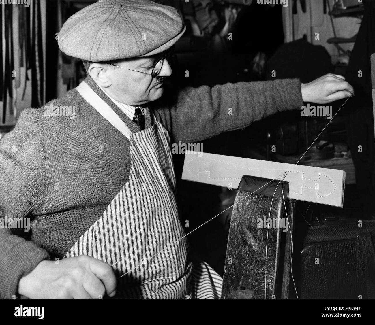 Années 1920 Années 1930 artisanat traditionnel Chandail Capuchon portant des lunettes ET TABLIER EN CUIR COUTURE POIGNÉE AVEC THREAD - q37468 CPC001 HARS, mi-longueur de l'intérieur TRADITIONNEL ARTISANAT PROFESSION COUDRE NOSTALGIE HOMME D'ÂGE MOYEN 40-45 ans 45-50 ans fil AIGUILLES MANUEL D'OCCUPATION COMPÉTENCES CONNAISSANCES CARRIÈRES AUTORITÉ FIERTÉ LA CRÉATIVITÉ DE FABRICATION COMMERCE QUALIFIÉS ARTISANS ARTISAN ARTISAN DE PRÉCISION MÂLES FINE B&W NOIR ET BLANC Portrait de l'origine ethnique de l'ARTISANAT DU CUIR POIGNÉES ARTISANALES PERSONNES ANCIENNE VICE Banque D'Images