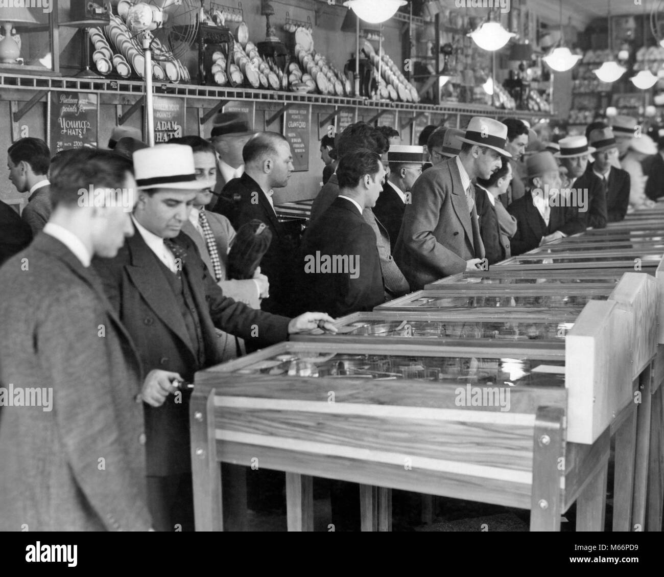 Groupe 1930 hommes portant des chapeaux en jouant les billards électriques dans la salle de Broadway, Times Square NEW YORK CITY USA - q74791 CPC001 HARS MIDTOWN EN ARCADE GOTHAM MACHINES LOISIRS EXCITATION NYC NEW YORK VILLES GROUPE DE PERSONNES NEW YORK CITY TIMES SQUARE, BROADWAY MI-hommes mi-ADULTES ADULT MAN B&W BIG APPLE NOIR ET BLANC PORTRAIT DE L'ORIGINE ETHNIQUE DES PERSONNES À L'ANCIENNE JEUX PINBALL Banque D'Images