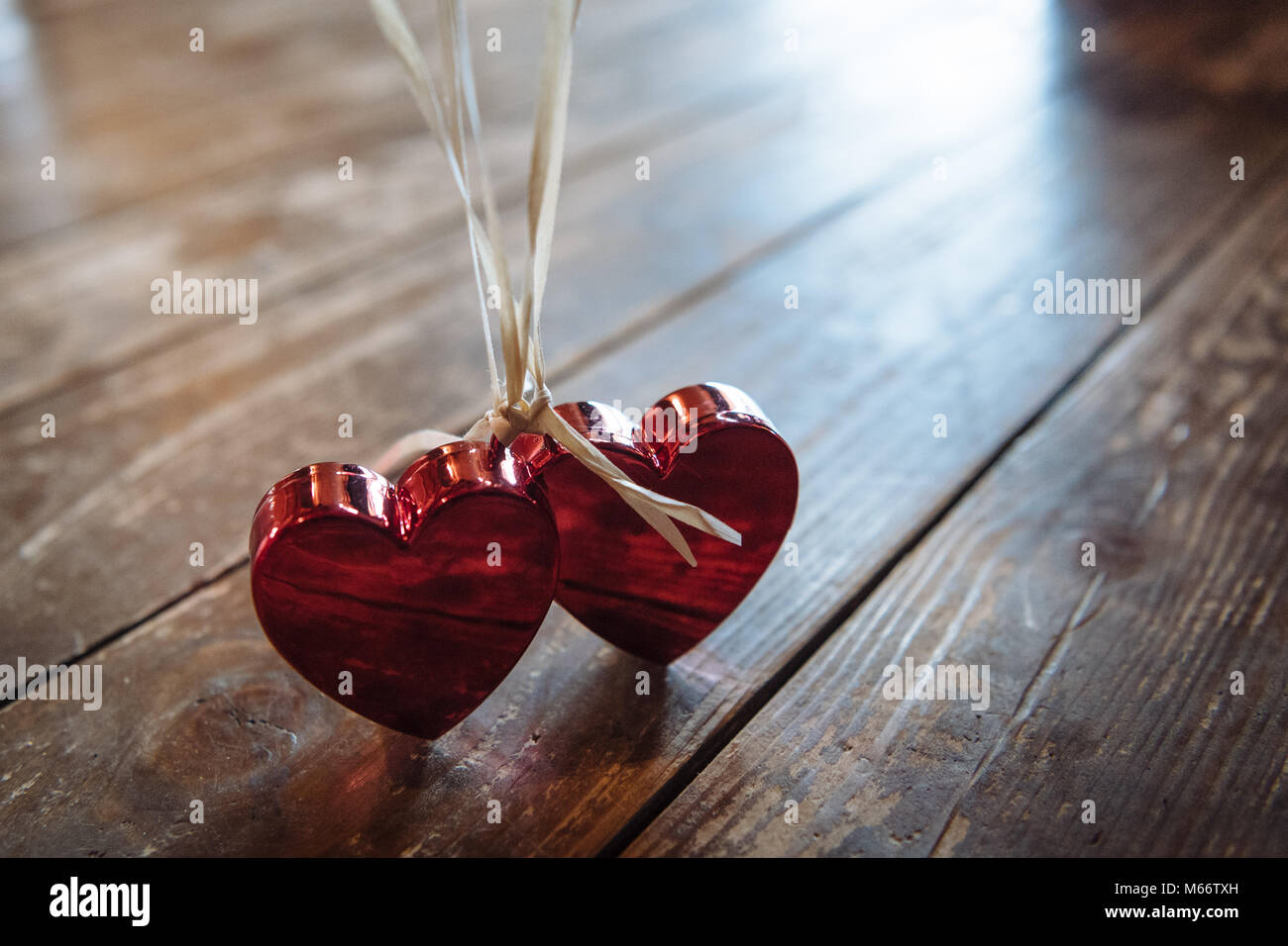 Photo symbole de l'Amour, mariage, partenariat, deux coeurs rouges sur fond blanc strings Banque D'Images