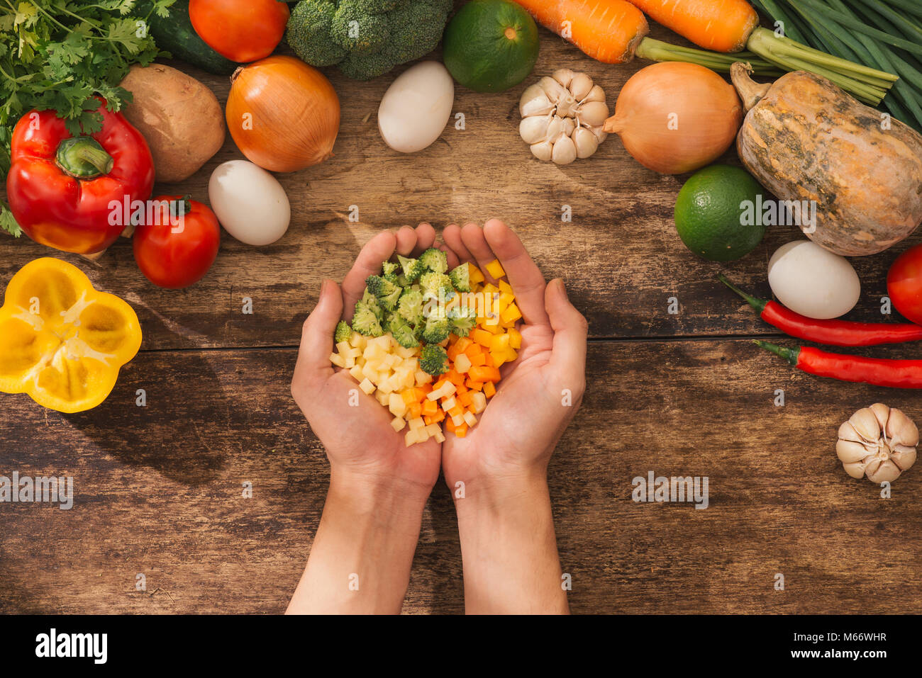 Légumes hachés sur les mains et le chef de cuisine végétarienne ingrédients savoureux. Vue d'en haut. Banque D'Images
