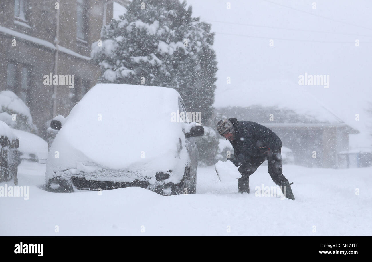 Frank Marshall déblayer la neige à Larbert, près de Falkirk, que storm Emma, roulant en provenance de l'Atlantique, semble prêt à affronter la bête de l'est fait froid la Russie - de l'air généralisée à l'origine de nouvelles chutes de neige et températures amer. Banque D'Images