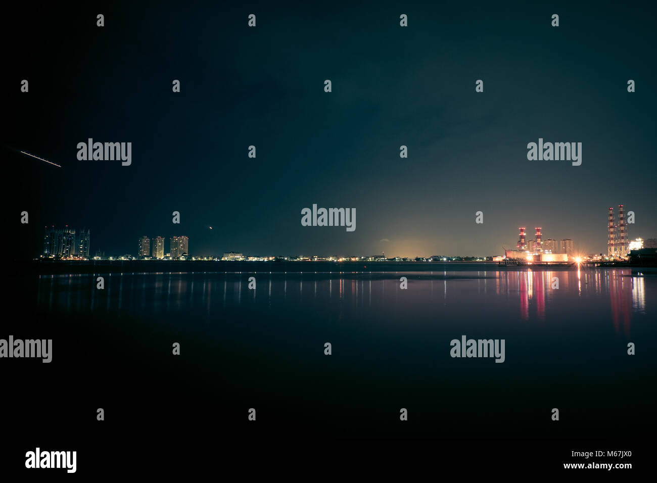 Sur le front de mer avec vue sur l'industrie urbaine à Jakarta Banque D'Images