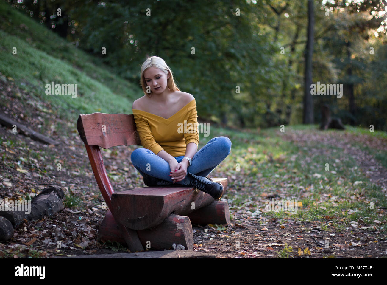 Jeune Femme Blonde Assise Seule Sur Un Banc En Bois Le Sentiment De Solitude Et Triste Photo Stock Alamy