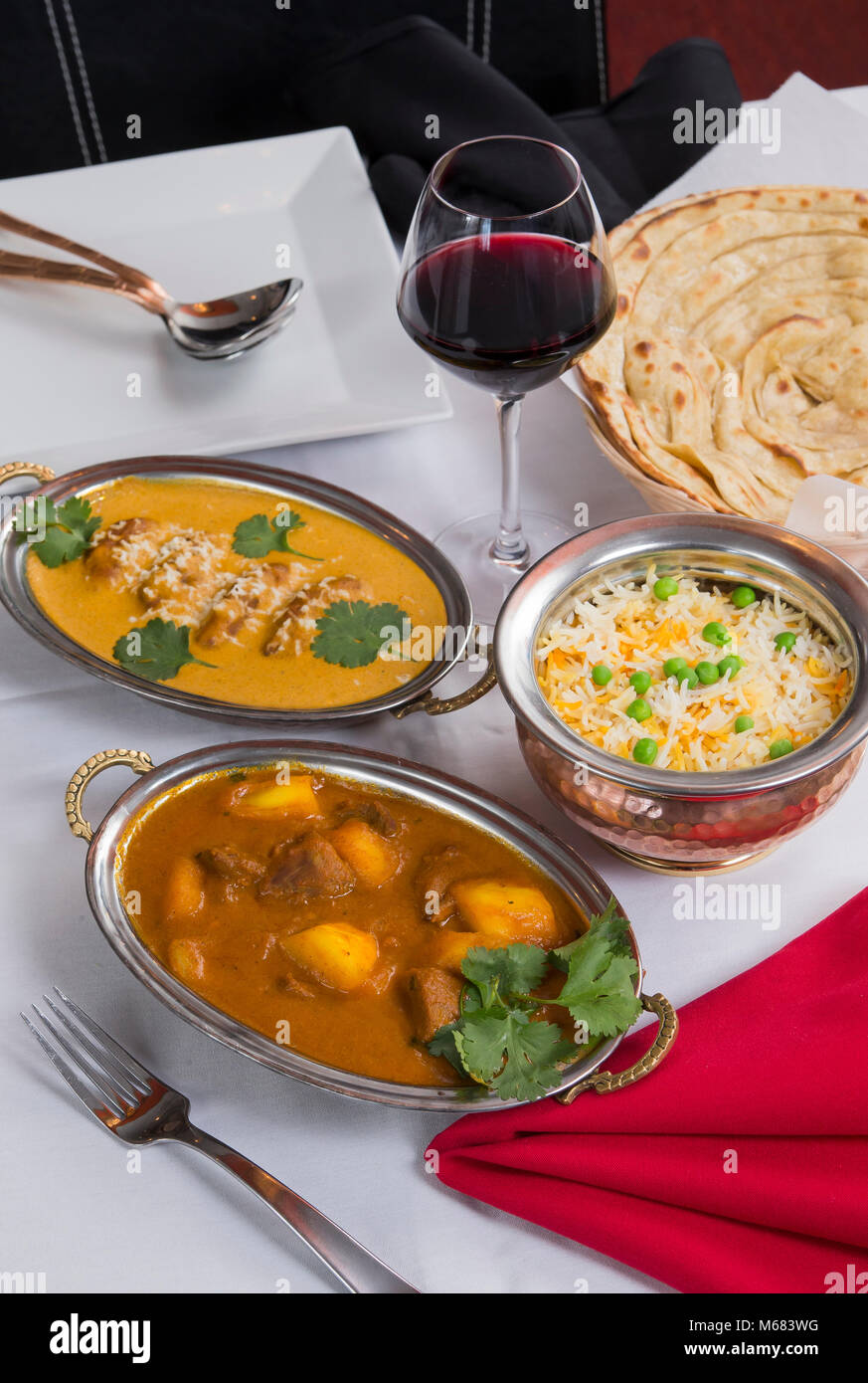 Aliments curry indien étendu sur une table de dîner de fantaisie avec du riz, de l'laccha, agneau Paratha Placez aam wala, safran malai kofta, vin rouge. Banque D'Images