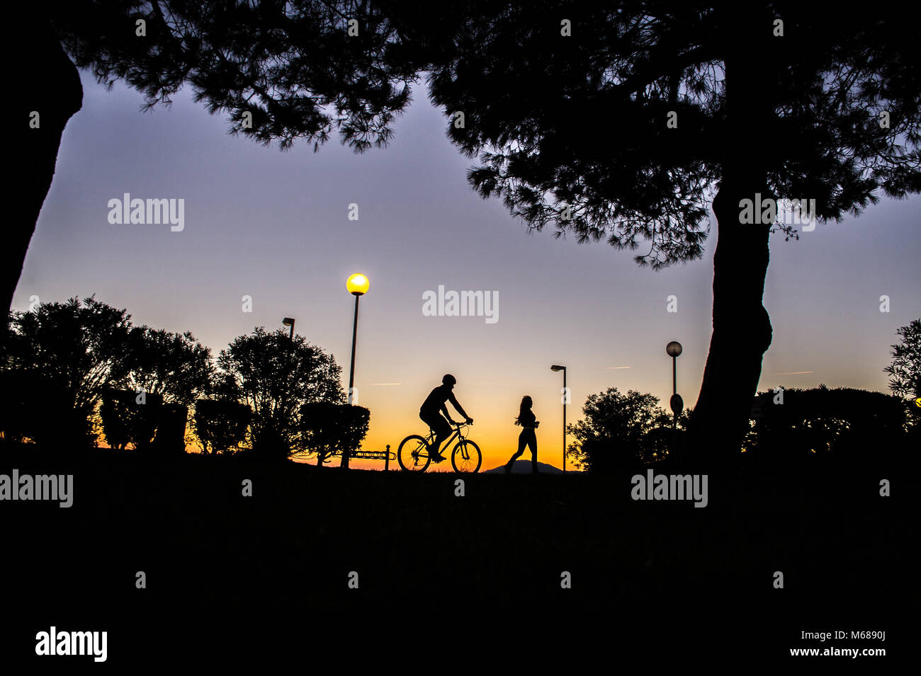 Argeles-sur-Mer (sud-est de la France). Deux jeunes gens équitation un vélo de montagne et le long du bord tôt le matin Banque D'Images