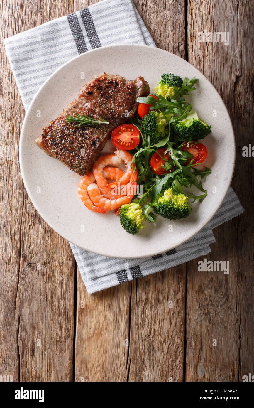 Juteux délicieux steak au barbecue et crevettes salade de légumes avec gros plan sur la plaque. Surf and Turf style. Haut Vertical Vue de dessus Banque D'Images