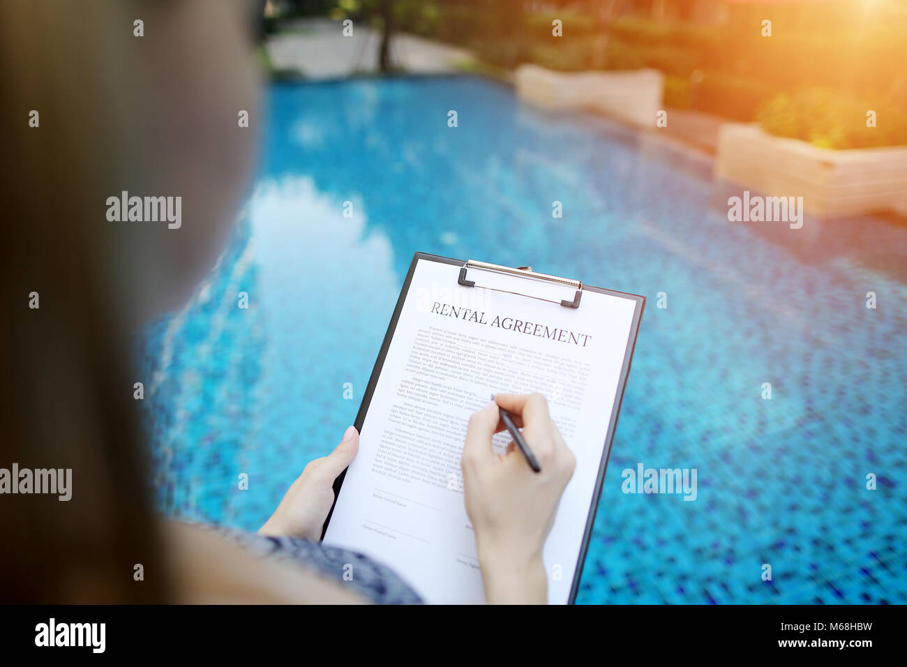Portrait de la signature de contrat de location sur fond de piscine. Utilisé avant avec Open Font License Banque D'Images