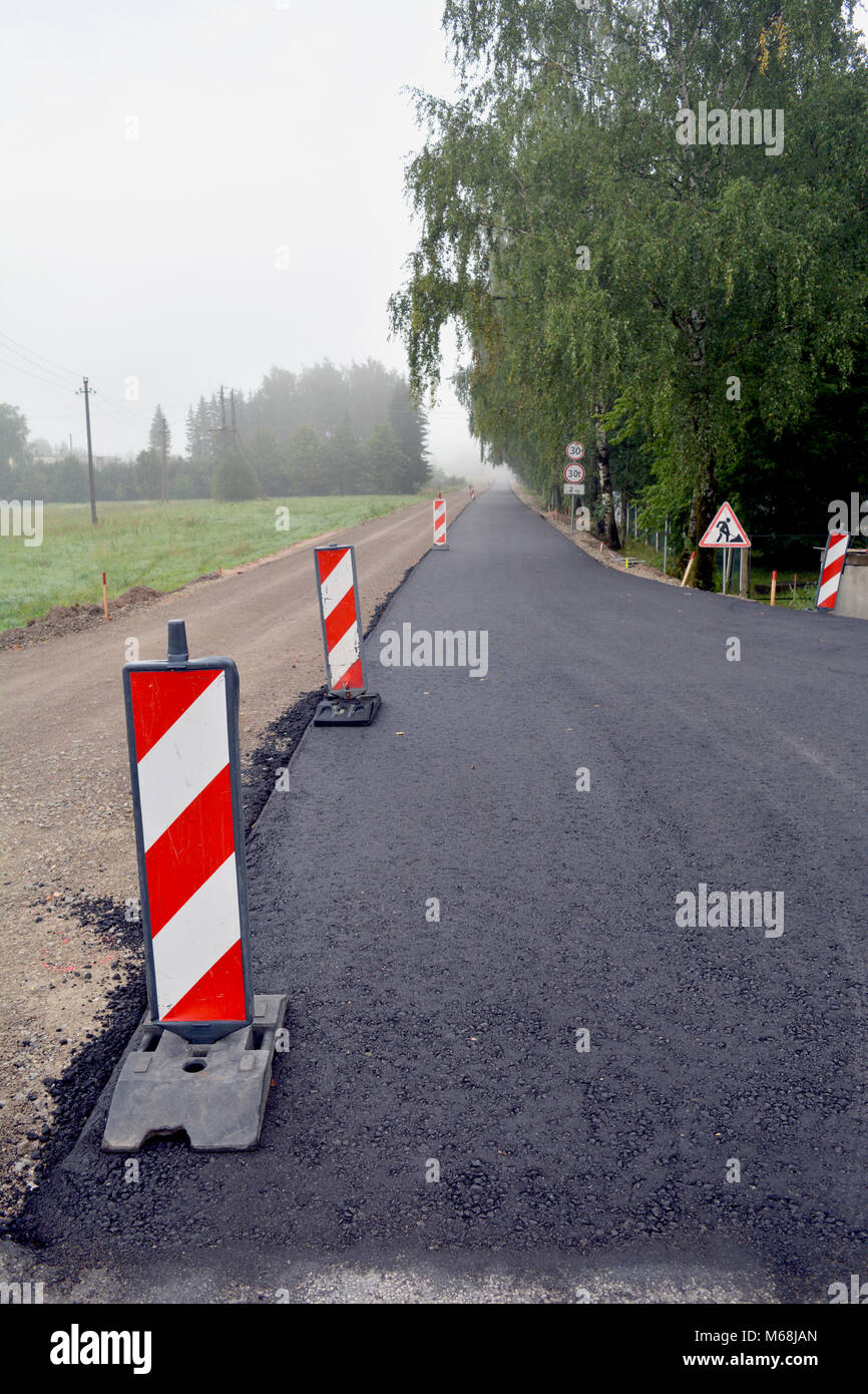 Nouvelle couche d'asphalte noir sur les routes en gravier, réparer la route Banque D'Images