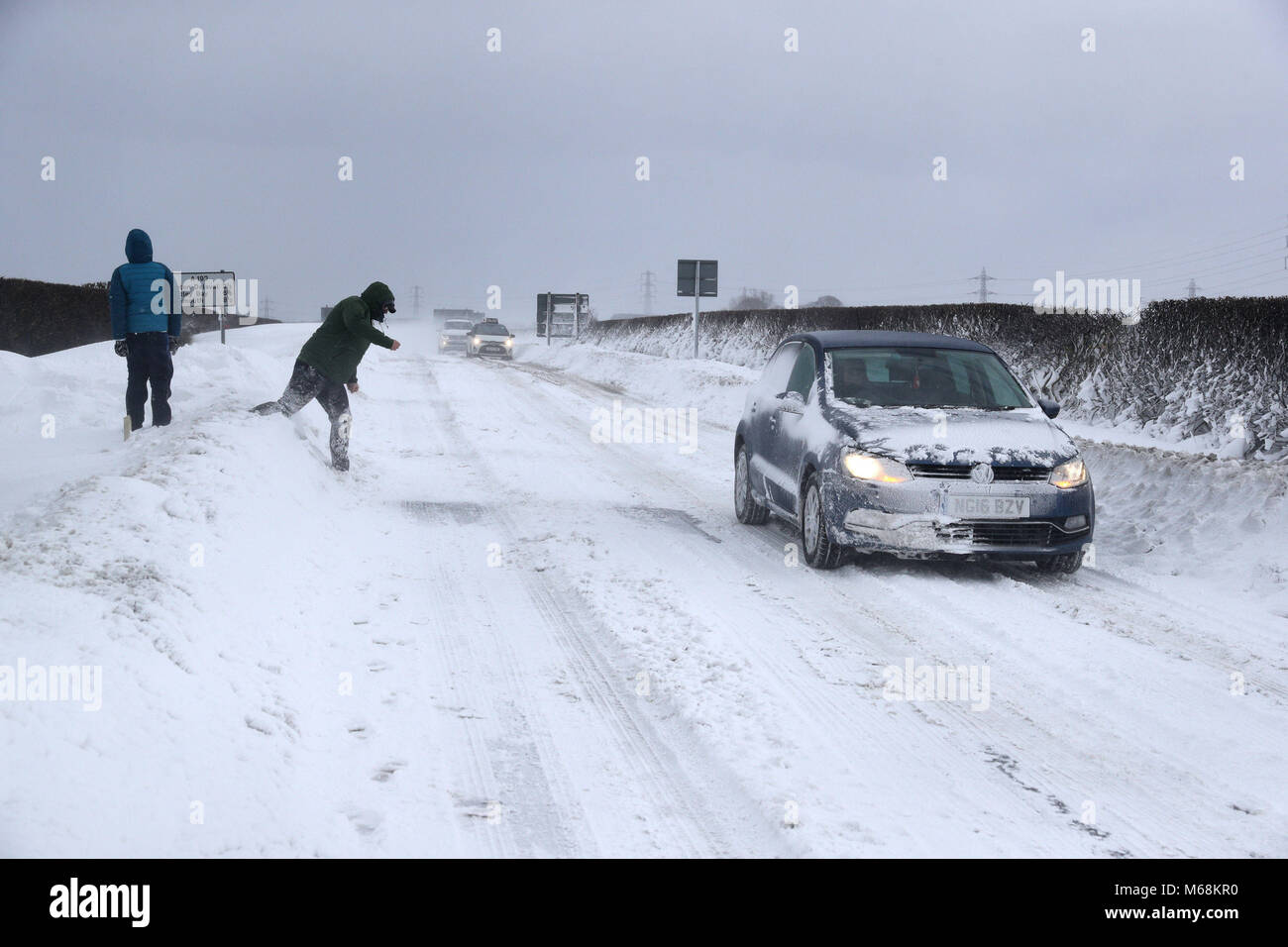 Les gens jettent boules de neige sur les véhicules qui circulent sur l'A192 près de Seaton Delaval, que storm Emma, roulant en provenance de l'Atlantique, semble prêt à affronter la bête de l'est fait froid la Russie - de l'air généralisée à l'origine de nouvelles chutes de neige et températures amer. Banque D'Images