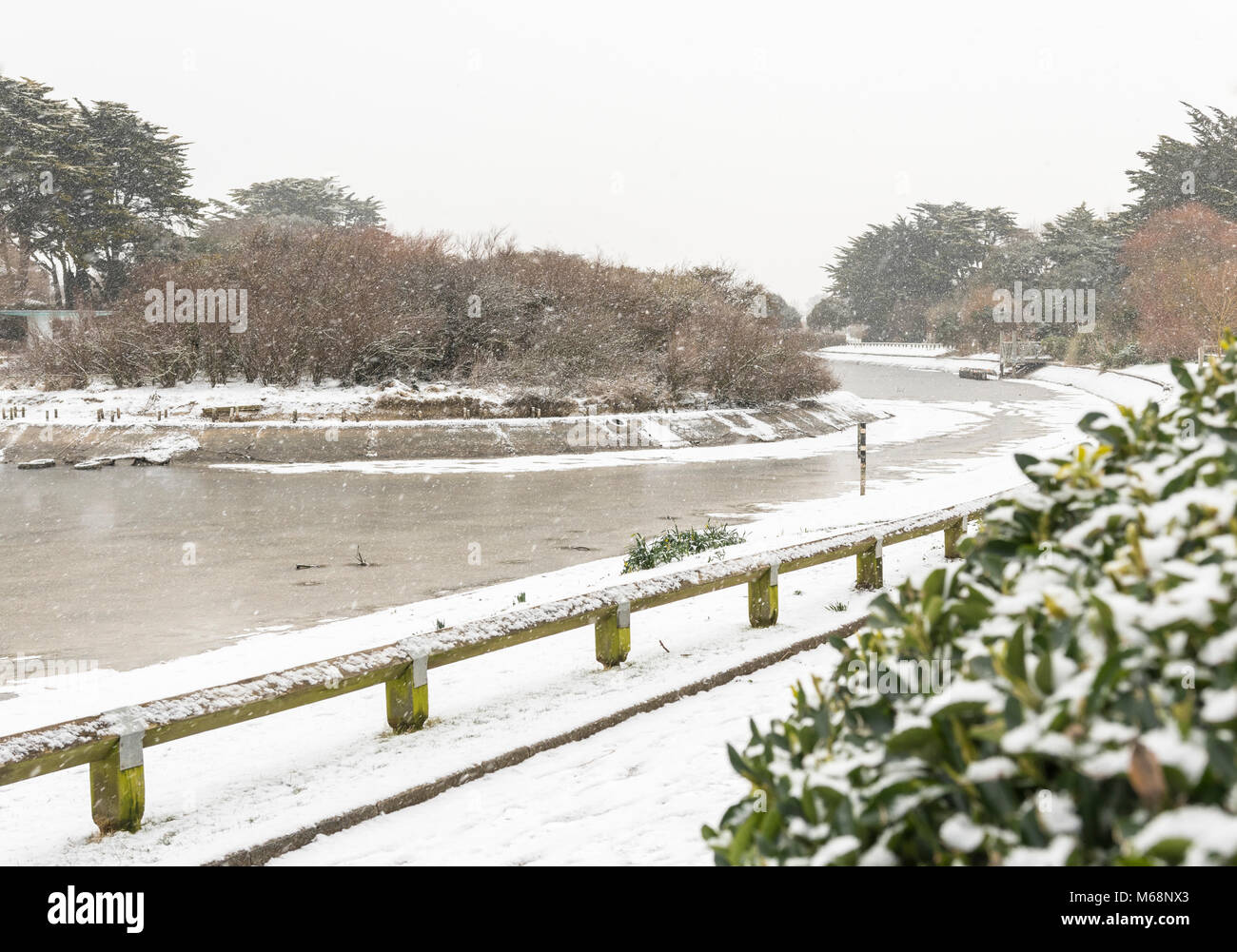La neige et la glace sur un lac gelé en hiver en Mewsbrook Park, Littlehampton, West Sussex, Angleterre, Royaume-Uni. Banque D'Images