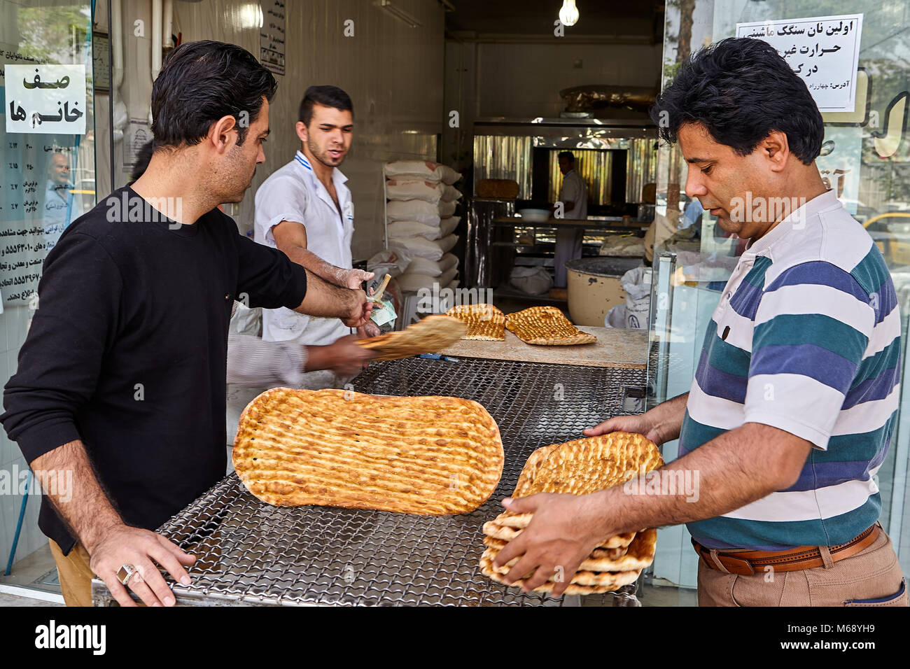 Kashan, Iran - 27 Avril 2017 : Les hommes acheter pain plat iranien appelé barbari dans le magasin à la boulangerie. Banque D'Images