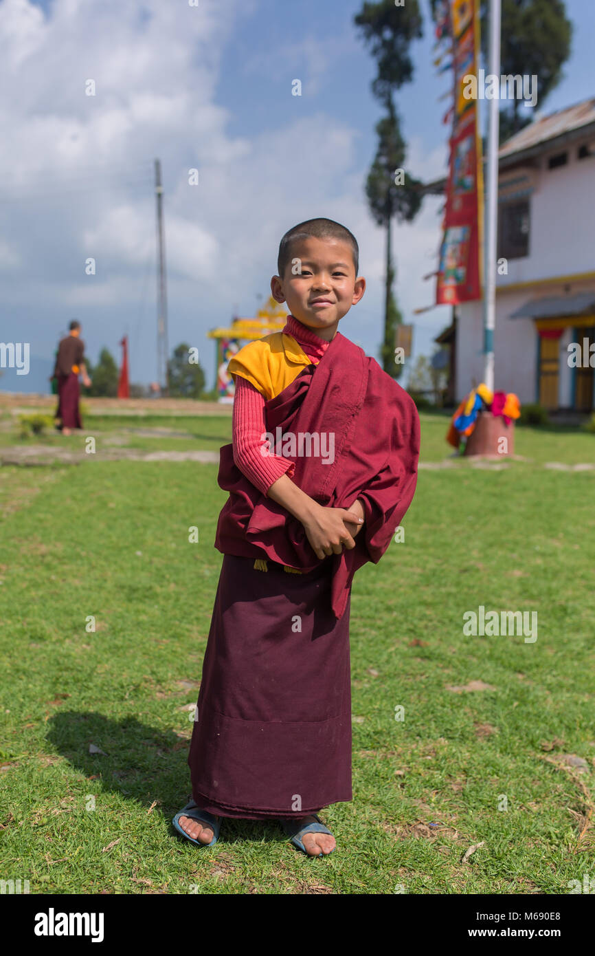 Pelling, Inde - le 26 avril 2017 : jeune moine bouddhiste novice en robes rouges traditionnel debout devant un monastère à Pelling, Sikkim, Banque D'Images