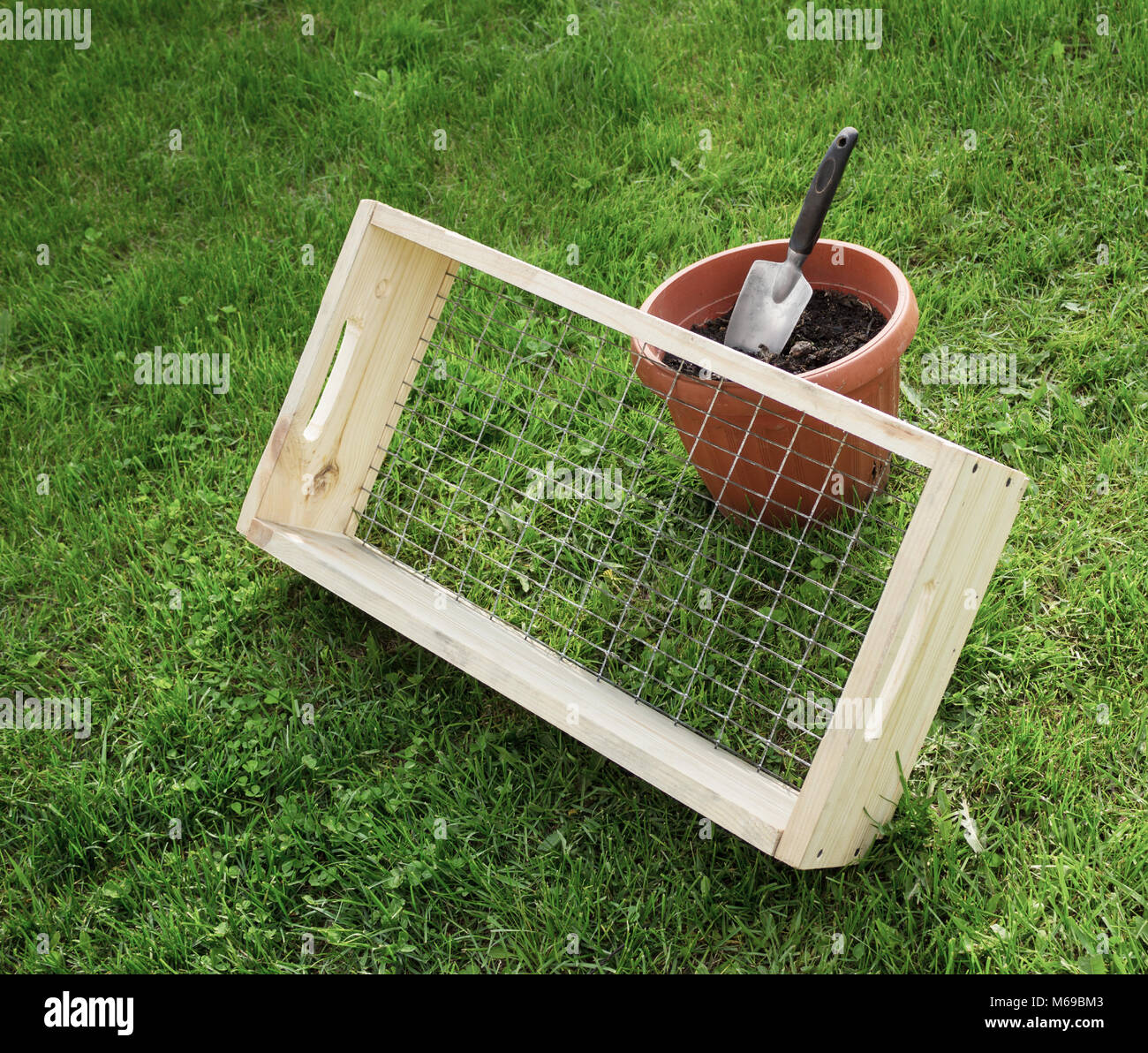 Tamis avec un cadre en bois pour le jardin fonctionne et scoop Photo