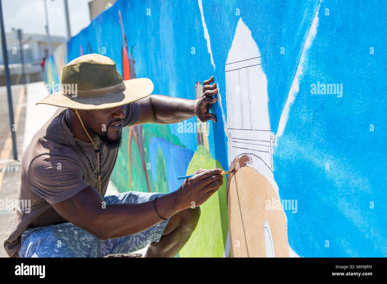 Antiguan man painting un moulin à vent, St John's, Antigua Banque D'Images