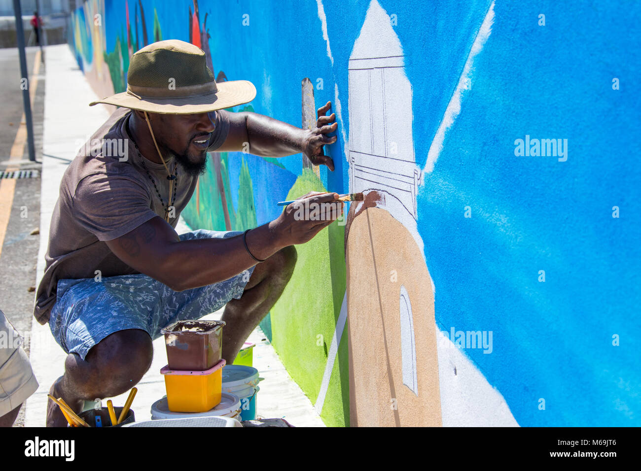Antiguan man painting un moulin à vent, St John's, Antigua Banque D'Images