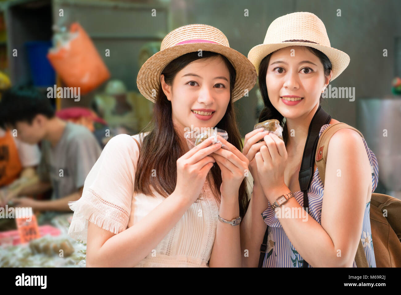 Joyeux de charme filles asiatiques visiter ville Jiufen et manger des aliments locaux gâteau à base de plantes sur la montagne de Taiwan, face à la caméra. Banque D'Images