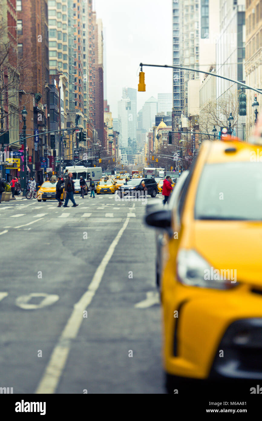 New York City, New York, USA - 19 Février 2018 : scène de rue de la ville de New York avec taxi jaune floue au premier plan et vue sur l'avenue. Banque D'Images