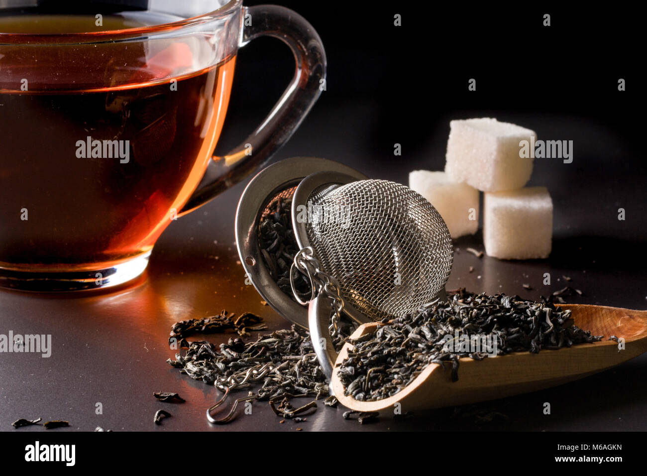 Tasse de thé avec une spatule sur un fond sombre. Banque D'Images