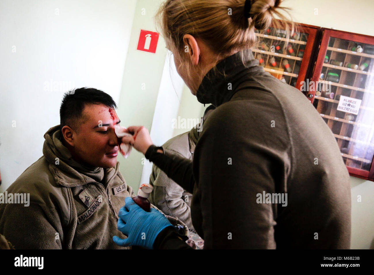 Le Sgt polonais. Frencho Zohra, un infirmier de la 11e Division de cavalerie blindée (droite), s'applique aux blessures faux U.S. Army PFC. Adrian Maldonado, un spécialiste des systèmes de prise en charge de signaux, avec le 82e bataillon du génie de la Brigade Blindée, 2e Brigade Combat Team, 1re Division d'infanterie, au cours d'un exercice de gestion de crise dans la région de Zagan, Pologne le 26 février 2018. La formation multinationale a été fait pour augmenter l'interopérabilité avec les premiers intervenants polonais et de forces armées alors qu'à l'appui de la résolution de l'Atlantique. (U.S. Army Banque D'Images