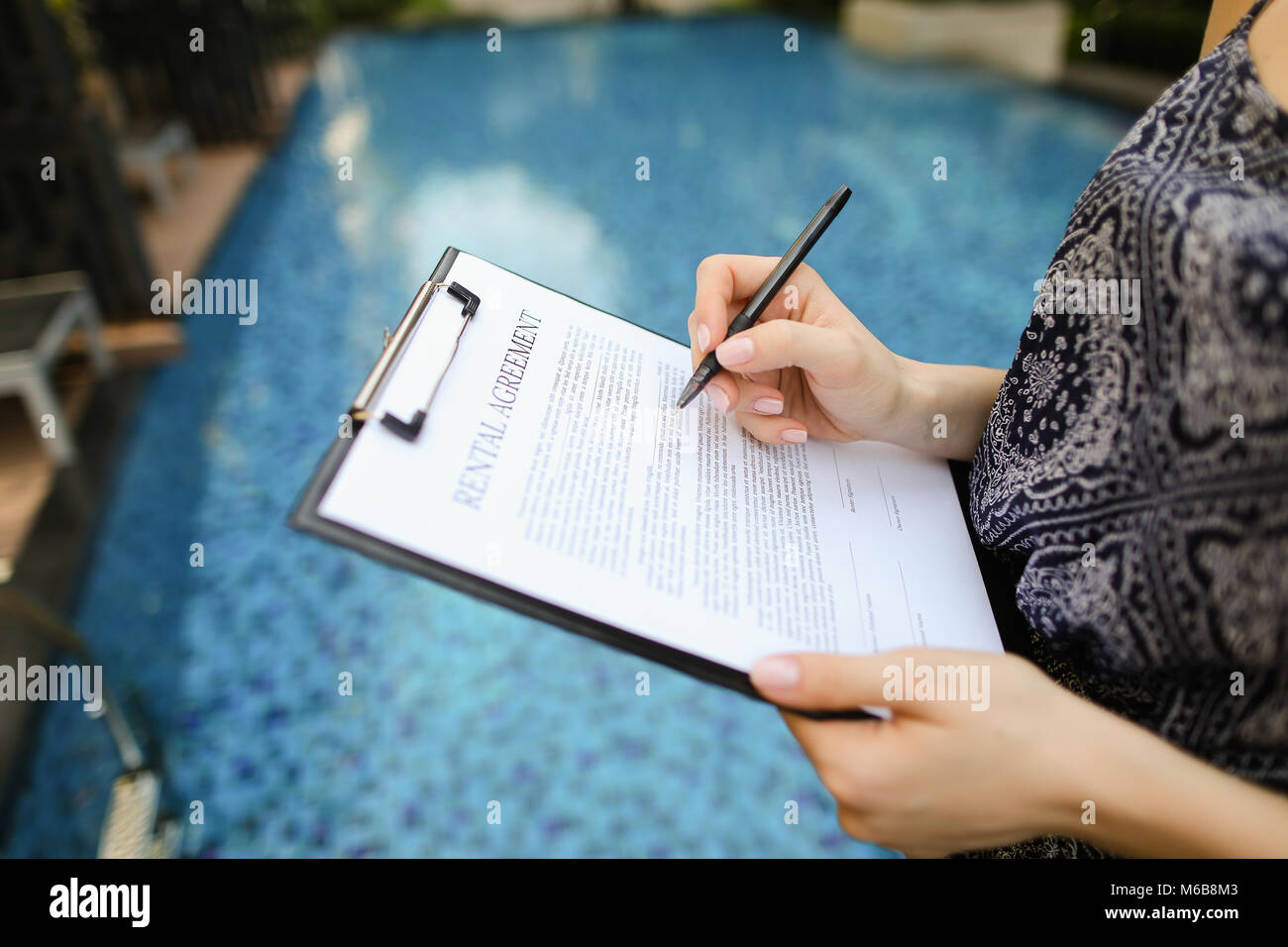 Close-up of hand of young woman signing document sur contexte o Banque D'Images