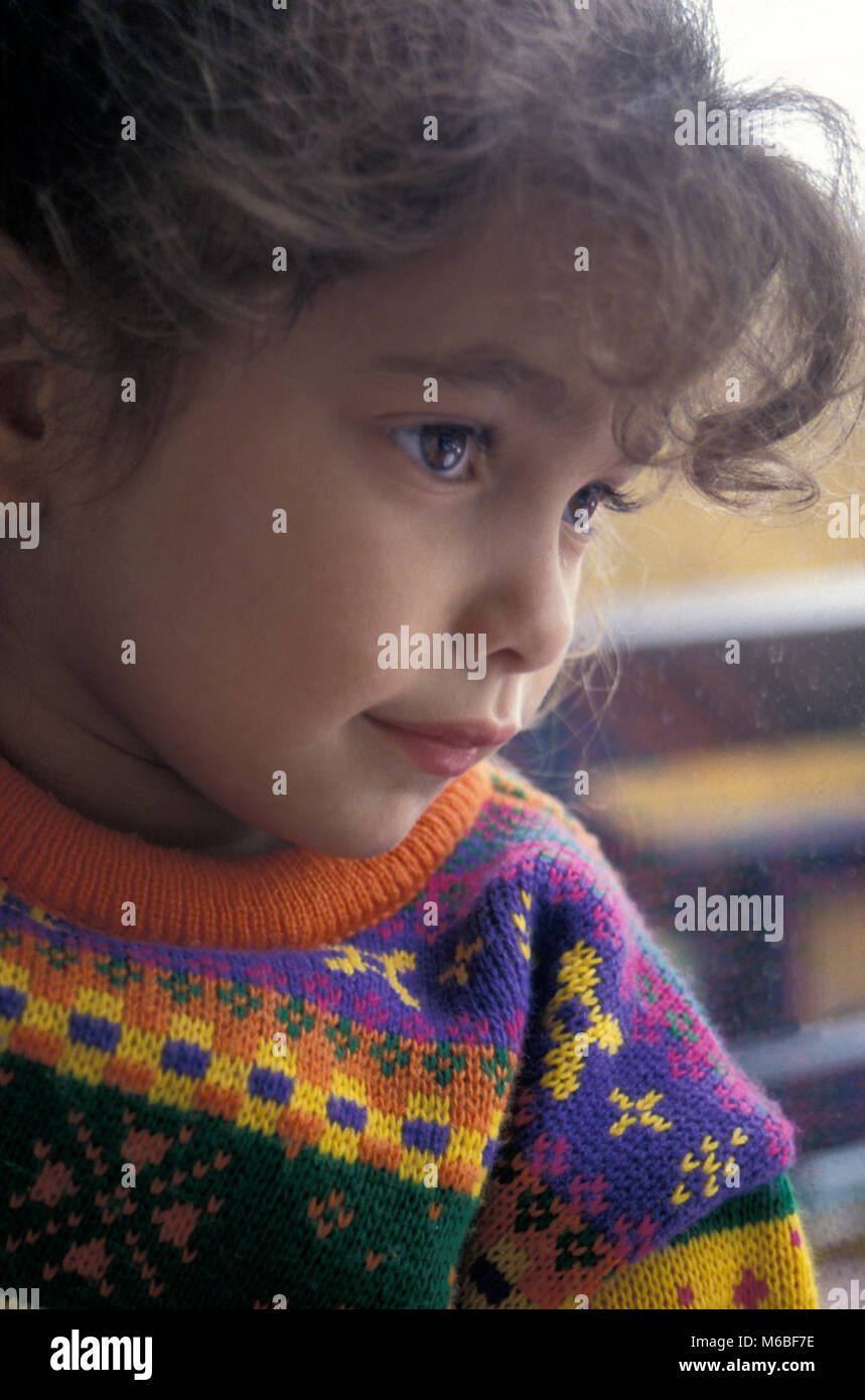 Petite fille contemplative à la fenêtre de Banque D'Images