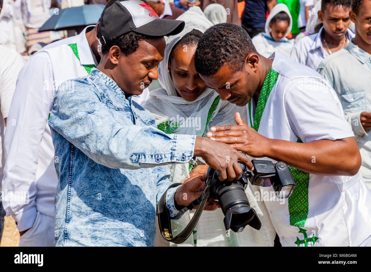 Un photographe éthiopien montre des photos de personnes au cours de Themeselves de Timkat (Epiphanie) Célébrations, Jan Sportsground Meda, Addis-Abeba, Ethiopie Banque D'Images