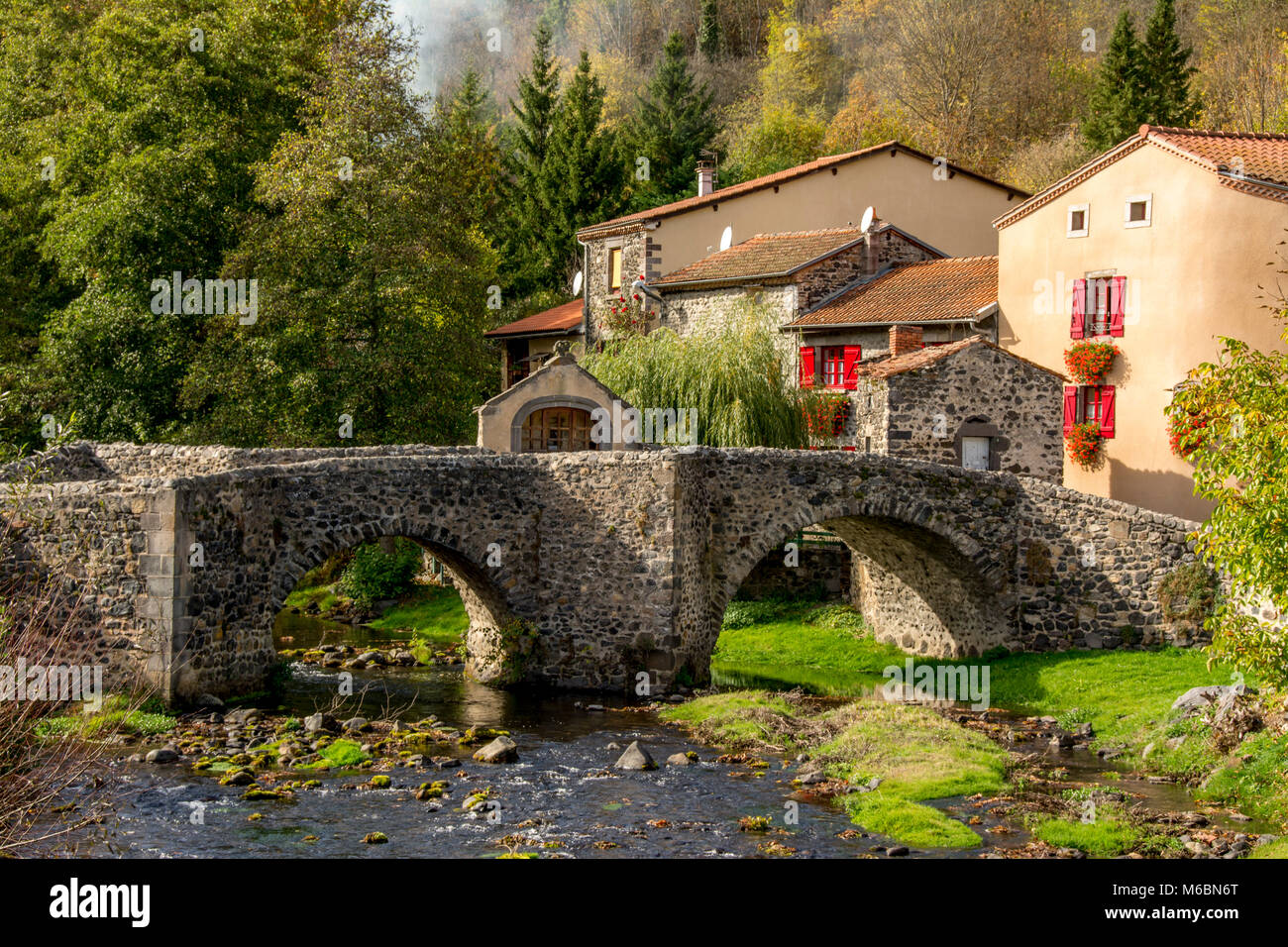 Pont en pierre sur le Pavin couze qui traverse le village de Saurier, Puy de Dome. Auvergne Rhône Alpes, France Banque D'Images