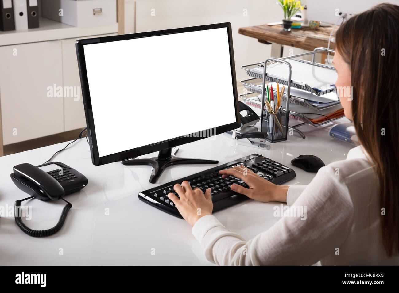 Young Businesswoman working on Ordinateur avec écran blanc Banque D'Images