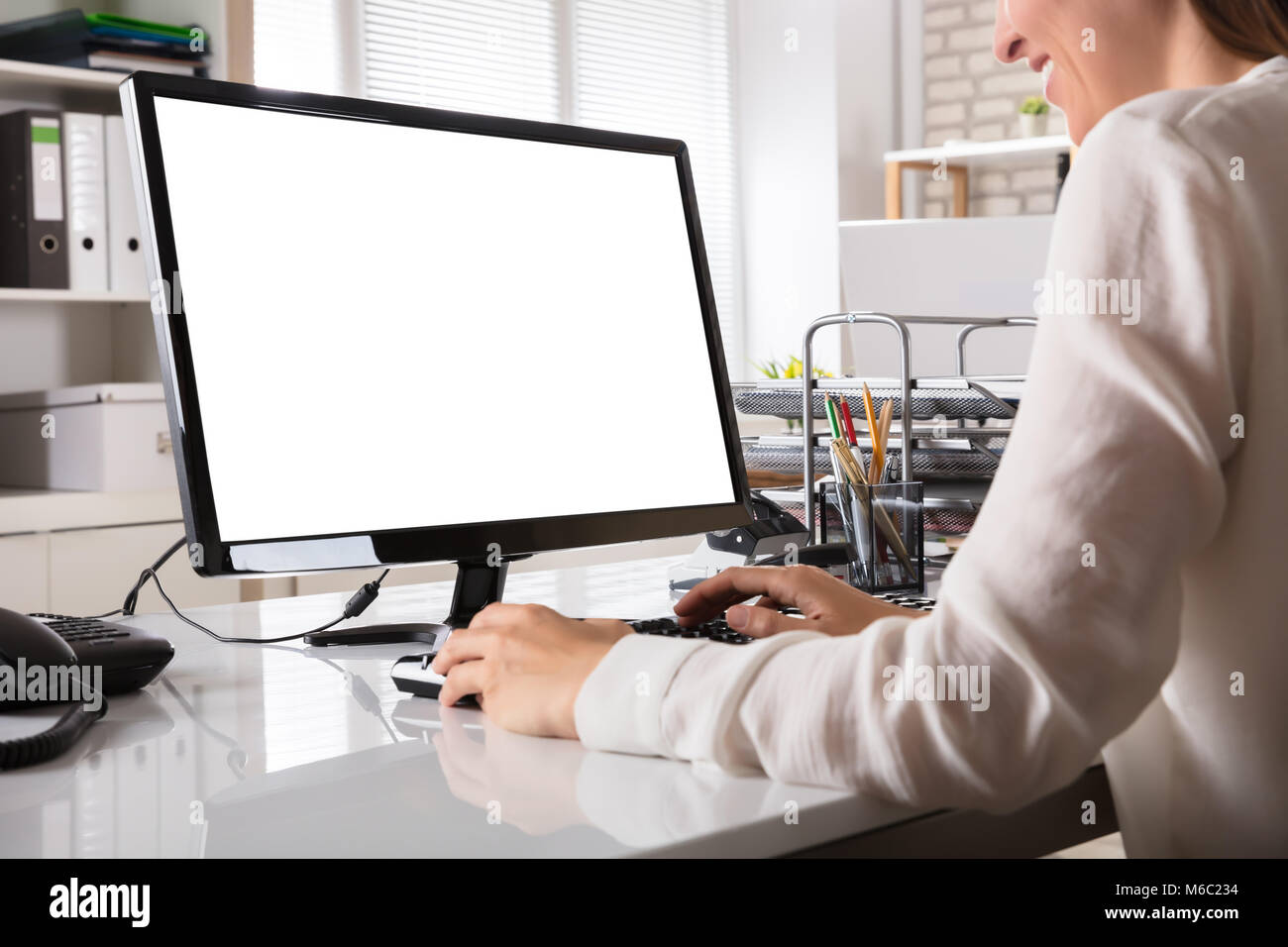 Young Businesswoman working on Ordinateur avec écran blanc Banque D'Images