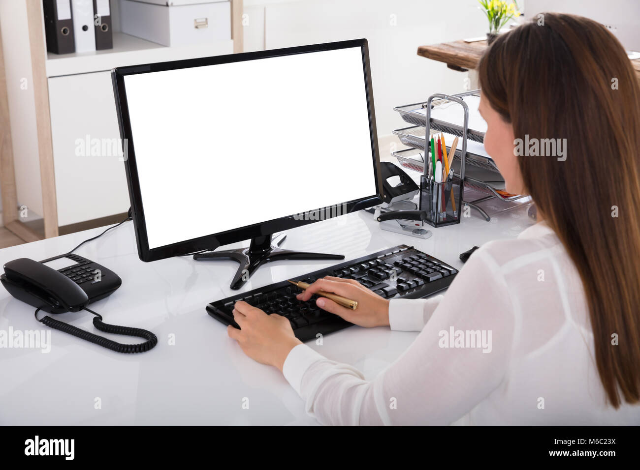 Young Businesswoman working on Ordinateur avec écran blanc Banque D'Images