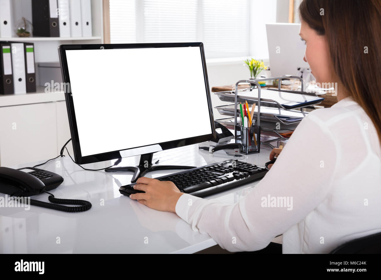 Young Businesswoman working on Ordinateur avec écran blanc Banque D'Images