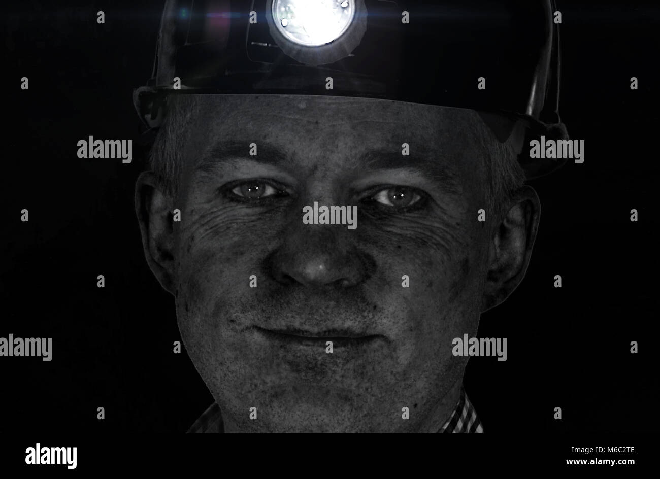 Smiling face sale de mineur de charbon dans la région de casque avec la lumière. Portrait détaillé de l'employé d'usine. Banque D'Images