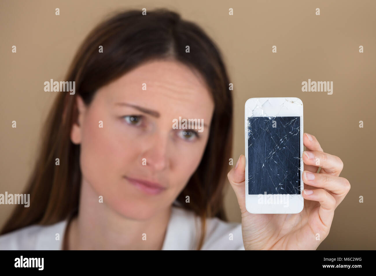 Close-up of Woman Holding malheureux Smart Phone avec écran fissuré Banque D'Images